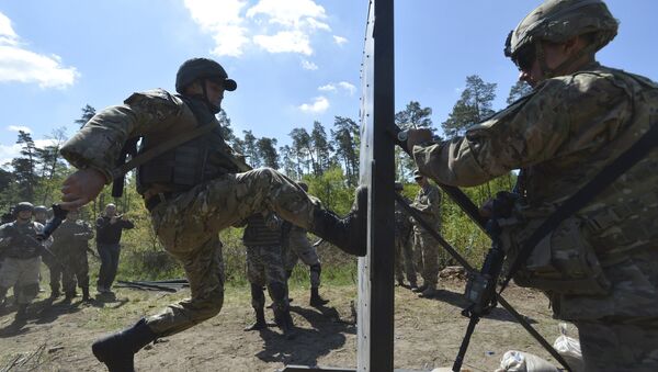 A serviceman of the U.S. Army's 173rd Airborne Brigade Combat Team (R) trains Ukrainian soldiers during a joint military exercise called Fearless Guardian 2015 - Sputnik Afrique