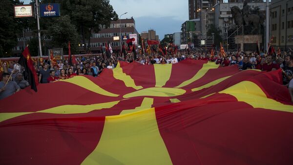 Supporters of the ruling VMRO-DPMNE party and Prime Minister Nikola Gruevski hold a Macedonian flag during a rally in Skopje, Macedonia, May 18, 2015 - Sputnik Afrique