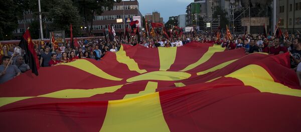 Supporters of the ruling VMRO-DPMNE party and Prime Minister Nikola Gruevski hold a Macedonian flag during a rally in Skopje, Macedonia, May 18, 2015 - Sputnik Afrique