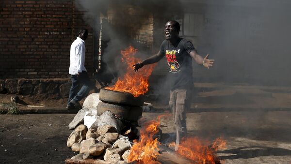 A protester, who is against President Pierre Nkurunziza's decision to run for a third term, gestures in front of a burning barricade in Bujumbura - Sputnik Afrique