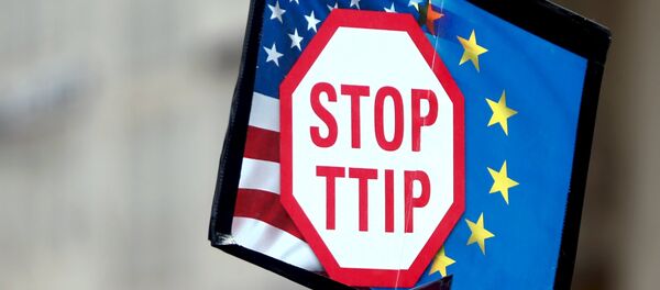 A protester holds signs during a demonstration against the Transatlantic Trade and Investment Partnership (TTIP), a proposed free trade agreement between the European Union and the United States, in Munich April 18, 2015. - Sputnik Afrique