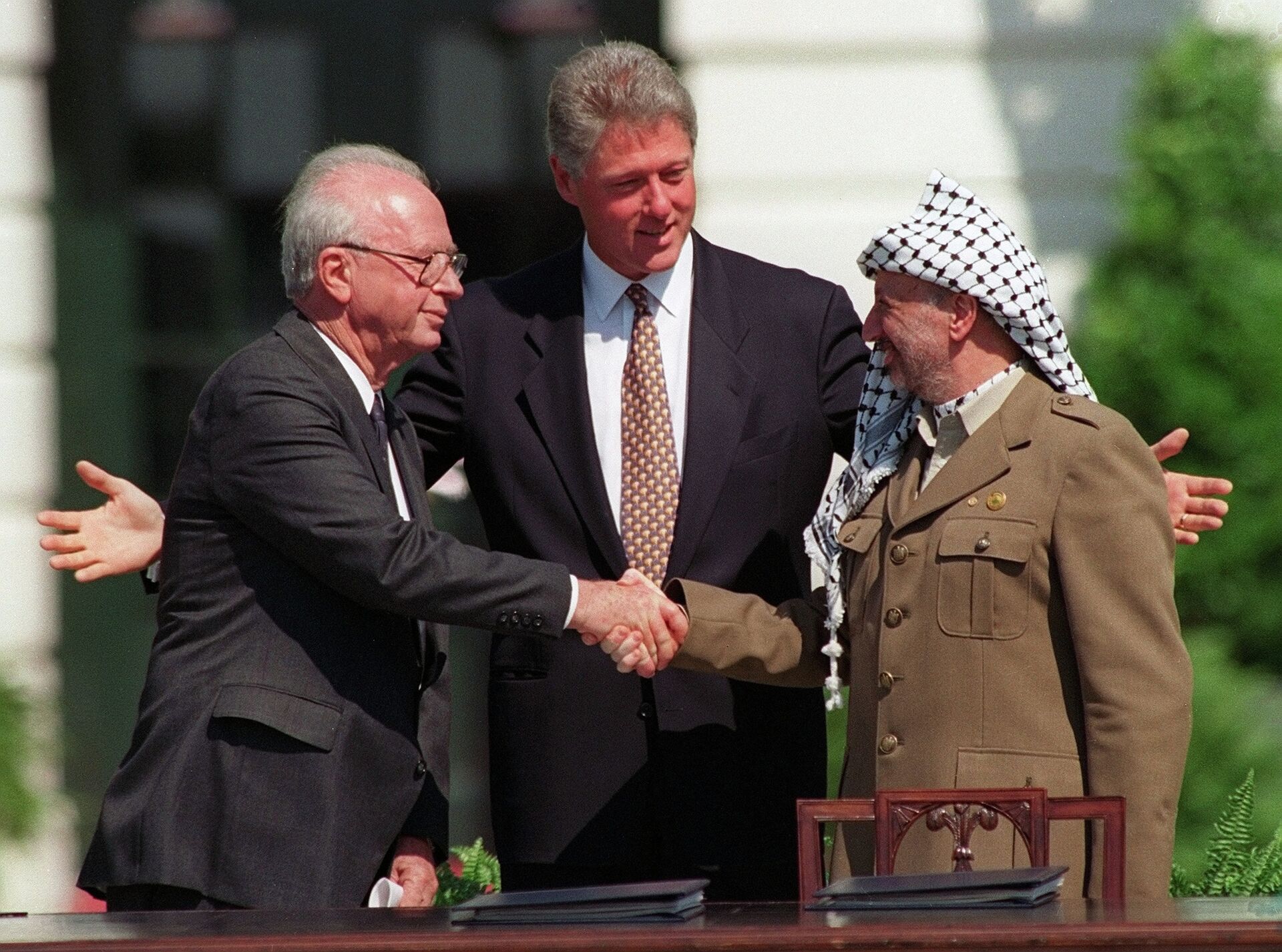 Israeli Prime Minister Yitzhak Rabin, left, and PLO chairman Yasser Arafat, right, shake hands as President Bill Clinton presides over the ceremony marking the signing of the 1993 peace accord between Israel and the Palestinians on the White House lawn, Sept. 13, 1993 - Sputnik Afrique, 1920, 09.10.2023