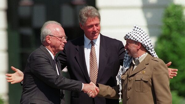 Israeli Prime Minister Yitzhak Rabin, left, and PLO chairman Yasser Arafat, right, shake hands as President Bill Clinton presides over the ceremony marking the signing of the 1993 peace accord between Israel and the Palestinians on the White House lawn, Sept. 13, 1993 - Sputnik Afrique