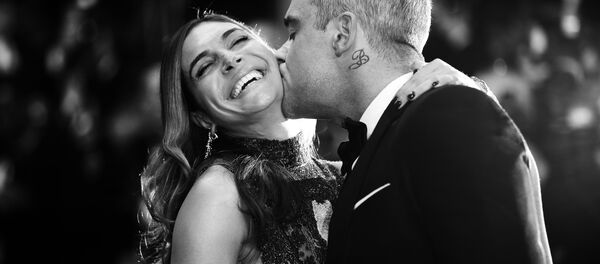 British singer Robbie Williams (R) kisses his wife Ayda Field as they arrive for the screening of the film The Sea of Trees at the 68th Cannes Film Festival in Cannes, southeastern France, on May 16, 2015 - Sputnik Afrique