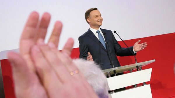 A supporter applauds Andrzej Duda, presidential candidate of the Law and Justice Party (PiS) after the exit polls on the second round of presidential elections in Warsaw - Sputnik Afrique