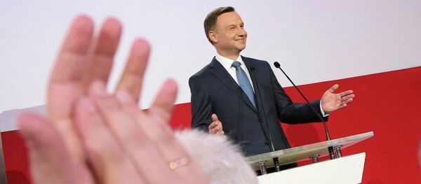 A supporter applauds Andrzej Duda, presidential candidate of the Law and Justice Party (PiS) after the exit polls on the second round of presidential elections in Warsaw - Sputnik Afrique