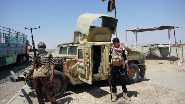 In this file photo, Islamic State group militants stand with a captured Iraqi army Humvee at a checkpoint outside Beiji refinery, around 155 miles north of Baghdad, Iraq. - Sputnik Afrique