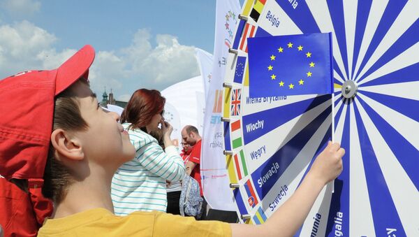 A boy holding a EU flag looks at a wheel with the names of all European Union countries during a picnic marking ten years since Poland joined the EU, in Warsaw, Poland, Thursday, May 1, 2014 - Sputnik Afrique
