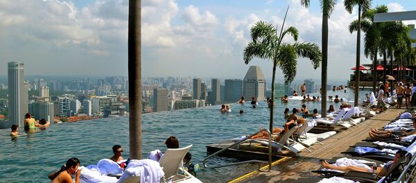 Des touristes près d'une piscine à Singapour. - Sputnik Afrique