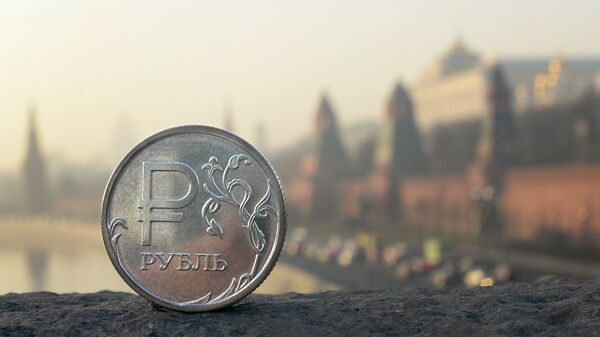 A Russian ruble coin is pictured in front of the Kremlin in central Moscow, on November 20, 2014 - Sputnik Afrique