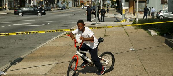 Stopped by police tape at the scene of a shooting where two men were shot at the intersection of West North Avenue and Druid Hill Avenue in West Baltimore - Sputnik Afrique