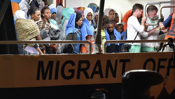 Migrants wait to disembark from the Migrant Offshore Aid Station (MOAS) ship Phoenix in the Sicilian port town of Augusta, Italy, Sunday, June 7, 2015 - Sputnik Afrique