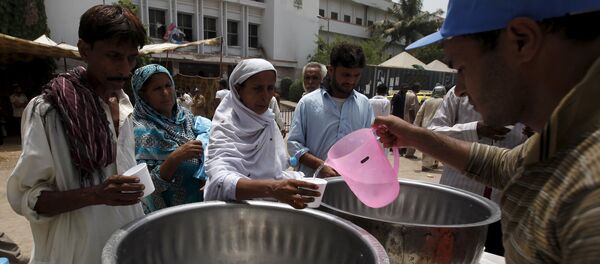 People receive drinking water from a volunteer at a stall, set up outside Jinnah Postgraduate Medical Centre (JPMC) during intense hot weather in Karachi, Pakistan, June 23, 2015. - Sputnik Afrique