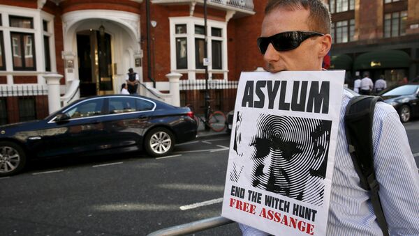 A supporter of Wikileaks founder Julian Assange holds a placard with his mouth during a gathering outside the Ecuador embassy in London, Britain June 19, 2015 - Sputnik Afrique