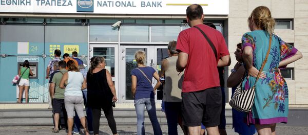 People line up to withdraw cash from an automated teller machine (ATM) outside a National Bank branch in Iraklio on the island of Crete, Greece - Sputnik Afrique