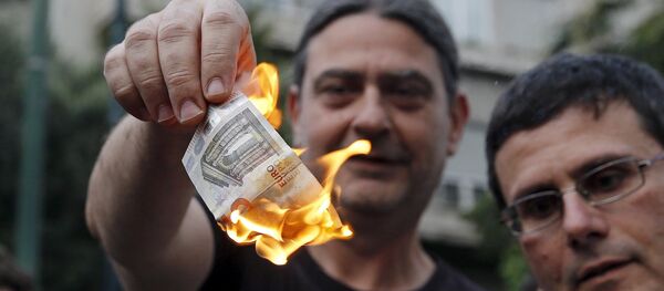 Мужчина сжигает евро-банкноту во время акции протеста против ЕС в Греции - Sputnik Afrique