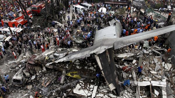 Security forces and rescue teams examine the wreckage of an Indonesian military C-130 Hercules transport plane after it crashed into a residential area in the North Sumatra city of Medan, Indonesia - Sputnik Afrique