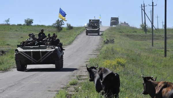 Members of the Ukrainian armed forces drive armoured vehicles and trucks as cows gather on the roadside near the village of Vidrodzhennya outside Artemivsk, Donetsk region, Ukraine, June 9, 2015. - Sputnik Afrique