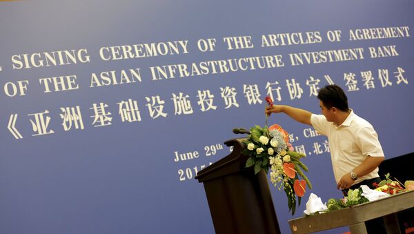 A worker decorates a lectern for a signing ceremony of articles of agreement of the Asian Infrastructure Investment Bank (AIIB), at the Great Hall of the People in Beijing, June 29, 2015. - Sputnik Afrique