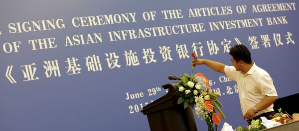 A worker decorates a lectern for a signing ceremony of articles of agreement of the Asian Infrastructure Investment Bank (AIIB), at the Great Hall of the People in Beijing, June 29, 2015. - Sputnik Afrique