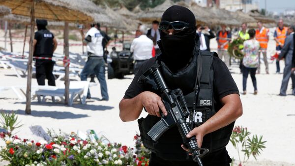 A hooded Tunisian police officer stands guard ahead of the visit of top security officials of Britain, France, Germany and Belgium at the scene of Friday's shooting attack in front of the Imperial Marhaba hotel in the Mediterranean resort of Sousse, Tunisa, Monday, June 29, 2015 - Sputnik Afrique