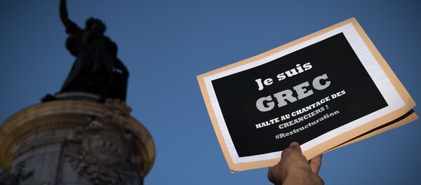 A person holds a banner reading I am a Greek, stop at blackmail creditors during a rally in Paris on July 5, 2015 A person holds a banner reading I am a Greek, stop at blackmail creditors during a rally in Paris on July 5, 2015 - Sputnik Afrique