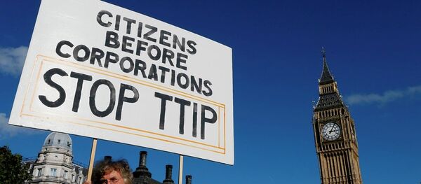A demonstrator holds a banner in Parliament Square in London, Saturday, Oct. 11, 2014. - Sputnik Afrique