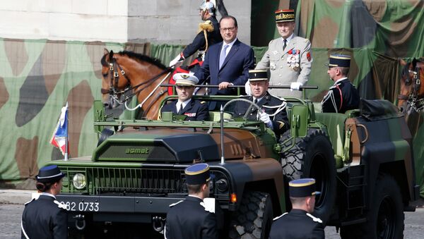 French President Francois Hollande (L) and French Army Chief-of-Staff General Pierre de Villiers stand in military vehicle during the annual Bastille Day military parade on July 14, 2015 in Paris - Sputnik Afrique