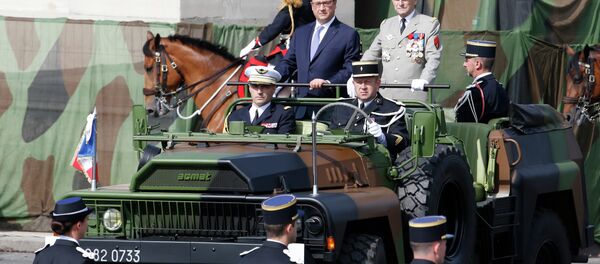 French President Francois Hollande (L) and French Army Chief-of-Staff General Pierre de Villiers stand in military vehicle during the annual Bastille Day military parade on July 14, 2015 in Paris - Sputnik Afrique