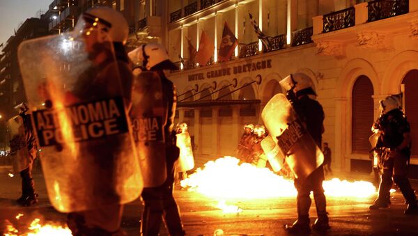 Riot police stand amongst the flames from exploded petrol bombs thrown by a small group of anti-austerity demonstrators in front of parliament in Athens, Greece July 15, 2015 - Sputnik Afrique