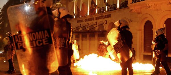 Riot police stand amongst the flames from exploded petrol bombs thrown by a small group of anti-austerity demonstrators in front of parliament in Athens, Greece July 15, 2015 - Sputnik Afrique