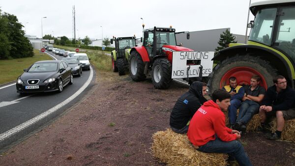 A group of farmers stages a blockade by the A84 road during a protest in the French town of Breteville-sur-Odon, near Caen on July 20, 2015. The farmers are protesting against high market prices in supermarkets and on July 20, began a blockage of the four main access points to the ring-road around the city of Caen - Sputnik Afrique
