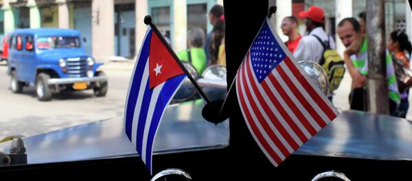 Miniature flags representing Cuba and the United States are displayed on the dash of an American classic car in Havana, Cuba. - Sputnik Afrique