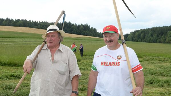 A picture taken on July 22, 2015 shows Belarus' President Alexander Lukashenko (R) and French actor Gerard Depardieu posing with their scythes at the Belarus President's official residence Ozerny, outside Minsk - Sputnik Afrique