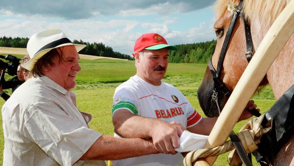 In this photo taken Wednesday, July 22, 2015, Belarus' President Alexander Lukashenko and French actor Gerard Depardieu, right, lead a horse in the presidential residence of Ozerny, outside Minsk, Belarus - Sputnik Afrique