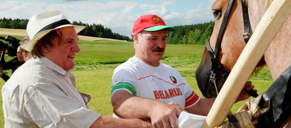 In this photo taken Wednesday, July 22, 2015, Belarus' President Alexander Lukashenko and French actor Gerard Depardieu, right, lead a horse in the presidential residence of Ozerny, outside Minsk, Belarus - Sputnik Afrique