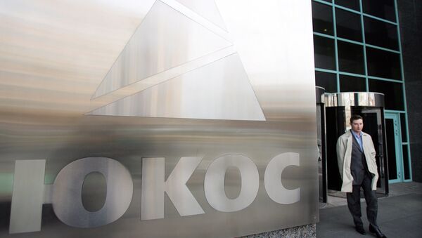 A man passes by a Yukos logo at the headquarters of the oil company in Moscow after the latest auction for the sale of package of assets the stricken giant, 04 April 2007 - Sputnik Afrique