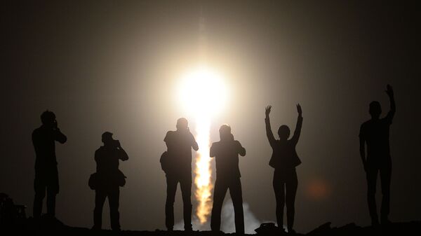 Люди наблюдают за запуском ракеты-носителя Союз-ФГ с пилотируемым кораблем Союз ТМА-13М и экипажем 40/41 экспедиций на МКС с космодрома Байконур - Sputnik Afrique