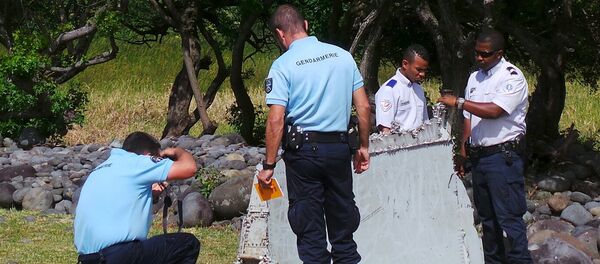 French gendarmes and police inspect a large piece of plane debris which was found on the beach in Saint-Andre, on the French Indian Ocean island of La Reunion, July 29, 2015. - Sputnik Afrique