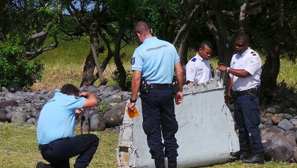 French gendarmes and police inspect a large piece of plane debris which was found on the beach in Saint-Andre, on the French Indian Ocean island of La Reunion, July 29, 2015. - Sputnik Afrique