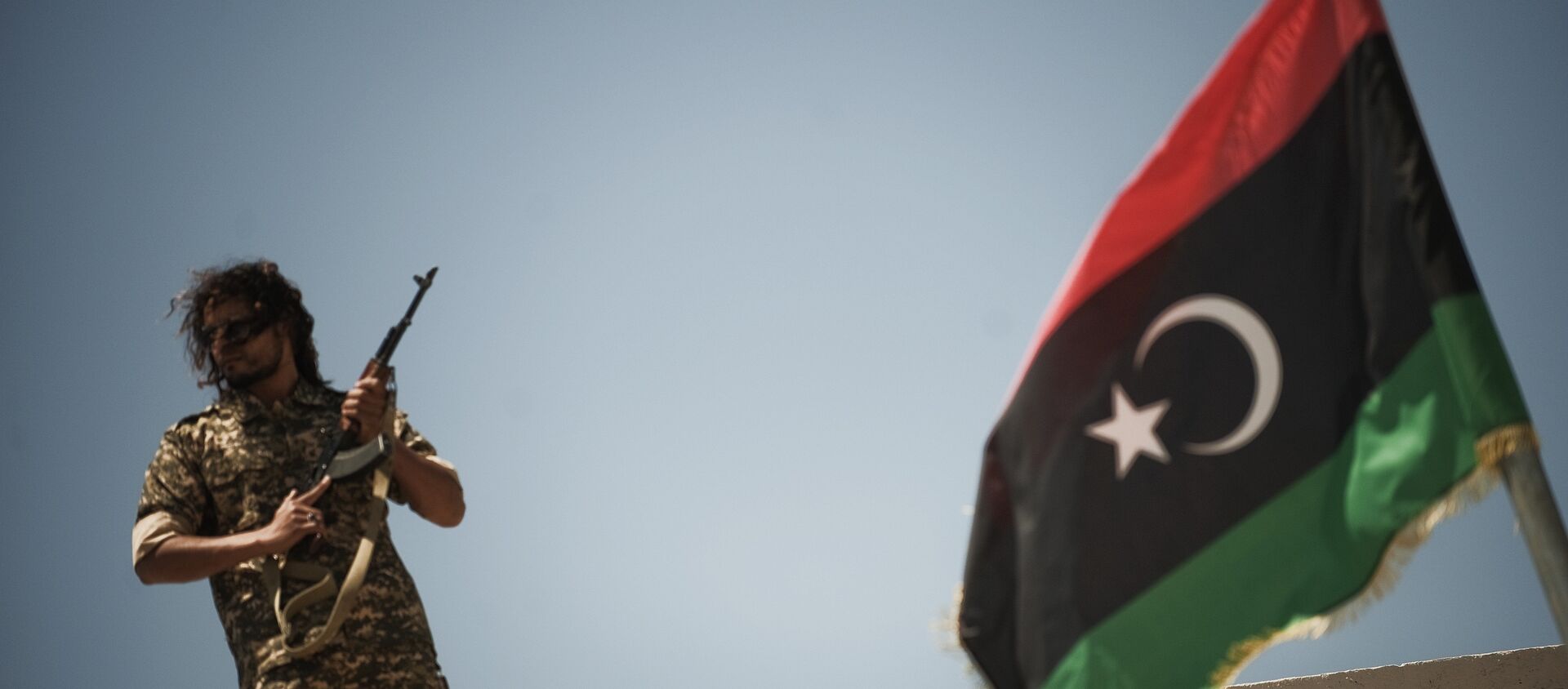 Un membre des forces de sécurité libyennes se tient sur un toit alors que le ministre libyen de la justice par intérim, Ali Hamiada, visite la nouvelle prison d'Al-Hadba et le tribunal spécial le 26 mai 2012 à Tripoli. La prison, qui peut accueillir 100 prisonniers politiques de haut rang, accueillera les procès des personnalités pro-mamer Kadhafi - Sputnik Afrique, 1920, 23.12.2020