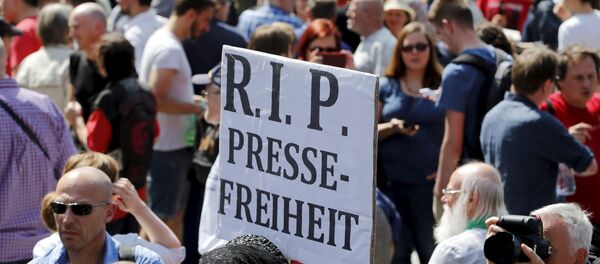 A demonstrator holds up a placard which reads Rest in Peace freedom of press! during a rally to protest against a criminal complaint by the domestic intelligence agency, the Office for the Protection of the Constitution (BfV), over articles about it that appeared on the Netzpolitik.org blog, in Berlin, Germany, August 1, 2015 - Sputnik Afrique