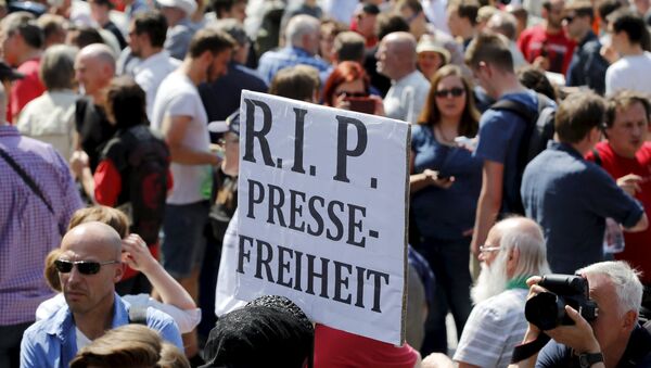 A demonstrator holds up a placard which reads Rest in Peace freedom of press! during a rally to protest against a criminal complaint by the domestic intelligence agency, the Office for the Protection of the Constitution (BfV), over articles about it that appeared on the Netzpolitik.org blog, in Berlin, Germany, August 1, 2015 - Sputnik Afrique