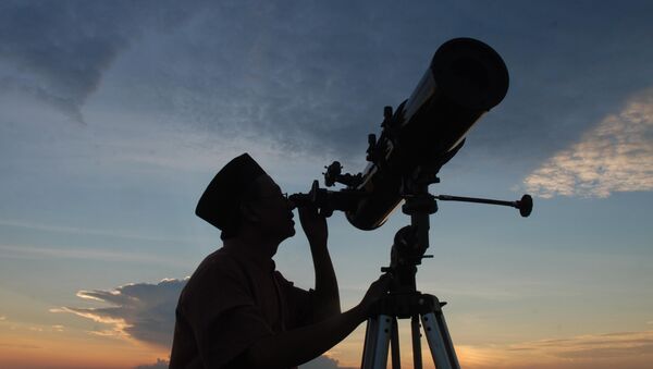 In this photograph taken on August 10, 2010 an official from the State Islamic University (STAIN), uses a telescope to observe the moon after sunset from the coast of Madura in East Java province of Indonesia on the eve of Ramadan - Sputnik Afrique
