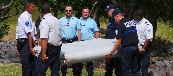 French gendarmes and police carry a large piece of plane debris which was found on the beach in Saint-Andre, on the French Indian Ocean island of La Reunion - Sputnik Afrique