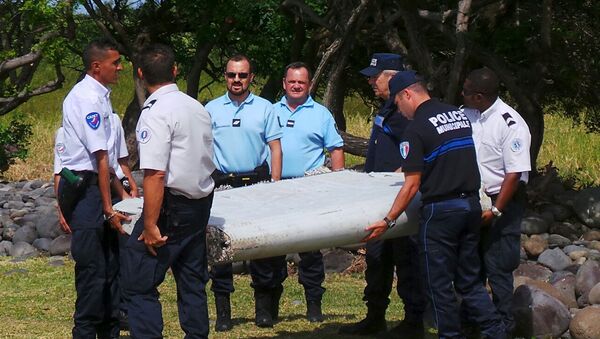 French gendarmes and police carry a large piece of plane debris which was found on the beach in Saint-Andre, on the French Indian Ocean island of La Reunion - Sputnik Afrique