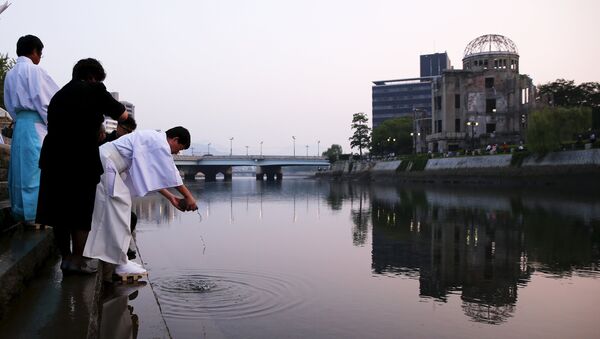 Shinto priests pray at the Motoyasu River opposite the Atomic Bomb Dome at sunrise in Hiroshima, western Japan, August 6, 2015. - Sputnik Afrique