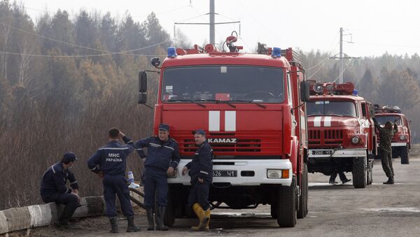 Firefighters stay on position in the Chernobyl zone on May 1, 2015 after nearly extinguished a forest fire near Chernobyl plant, which came within about 20 kilometres (12 miles) of Chernobyl after breaking out on April 28, 2015, - Sputnik Afrique