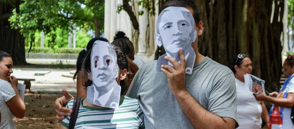 Cuban dissidents wear masks depicting US President Barack Obama as they protest against the reopening of the US embassy in the island, during a meeting of the Ladies in White human rights group in a park of Havana, on August 9, 2015. - Sputnik Afrique