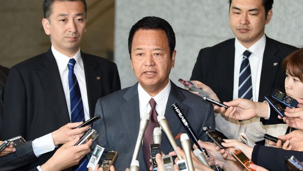 Japan's Economic Revitalisation Minister Akira Amari (C) answers questions from reporters upon his arrival at his office ahead of talks with visiting US Trade Representative Michael Froman (not pictured) over deadlocked Trans-Pacific Partnership (TPP) negotiations in Tokyo on April 20, 2015. - Sputnik Afrique
